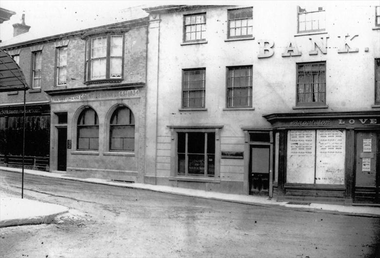 Photograph. Market Place end of Kings Arms Street. Cubitt's Grocers on left; Capital & Counties Bank; London & Provincial Bank; Loveless, flavouring essences. (North Walsham Archive).