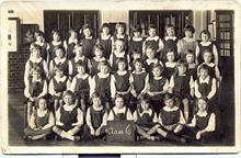 Thelma London at school in Lodin during the second world war. Thelma is holding the placard.