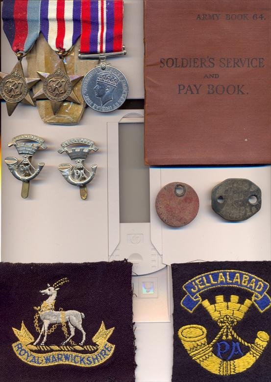Photograph. Dennis Solly's medal, badges, service books and other things he was issued with during the war. (North Walsham Archive).