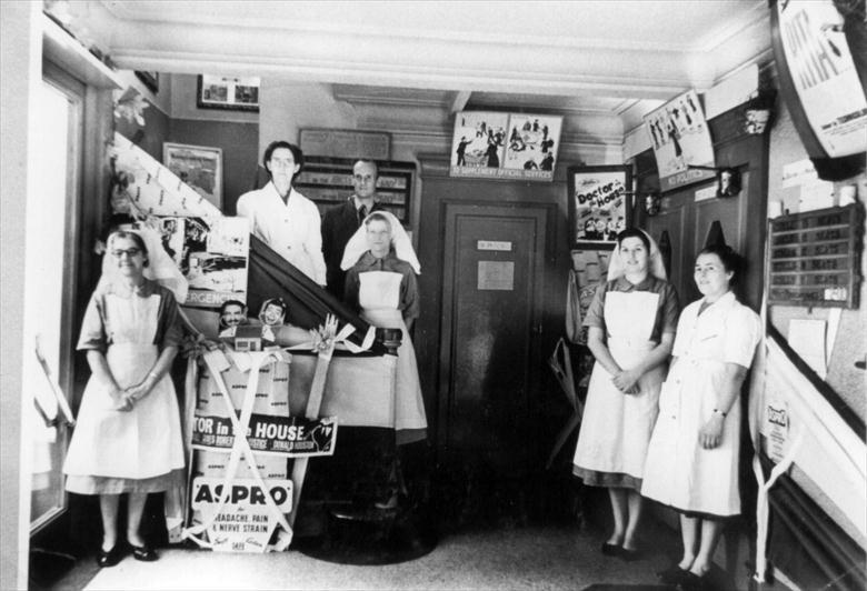 Photograph. Foyer of Regal Cinema, New Road, North Walsham. Staff dressed for "Doctor in the House" film (North Walsham Archive).