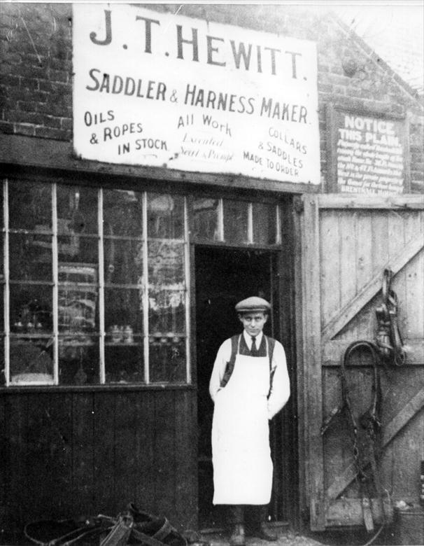 Photograph. George Turner outside John Hewitt's Saddlery on Church Plain, Vicarage Street, North Walsham (North Walsham Archive).