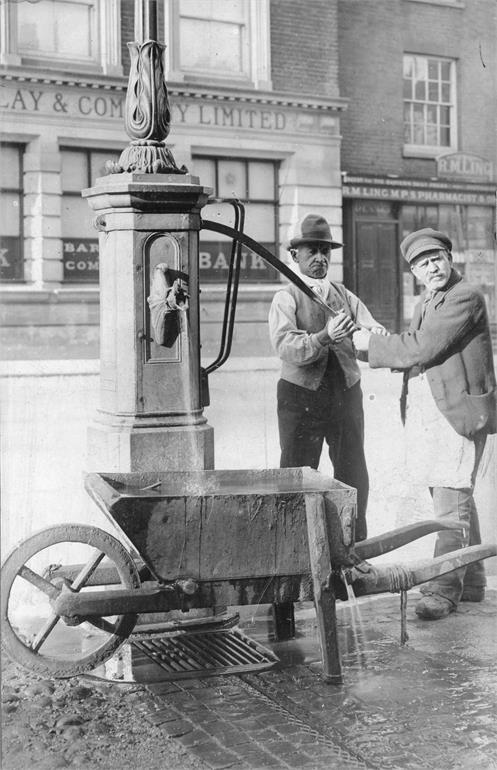 Photograph. North Walsham Market Place. Preparing to flush the surface drains (North Walsham Archive).