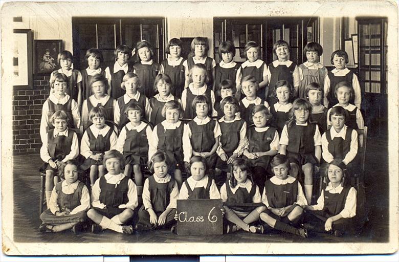 Photograph. Thelma London at school in Lodin during the second world war. Thelma is holding the placard. (North Walsham Archive).