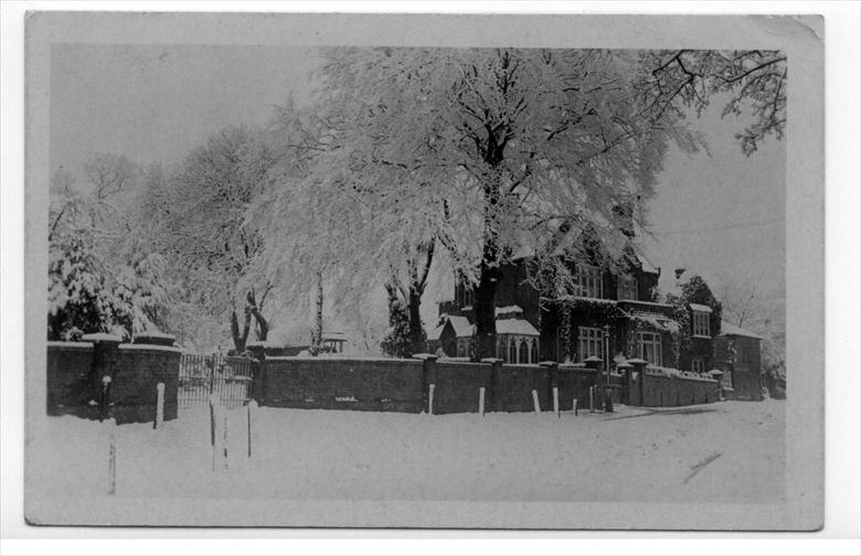 Photograph. Tudor House, 8 Grammar School Road, North Walsham, in snow ( then home of John Dixon, organist, auctioneer, etc). Paston School gates on the left. (North Walsham Archive).