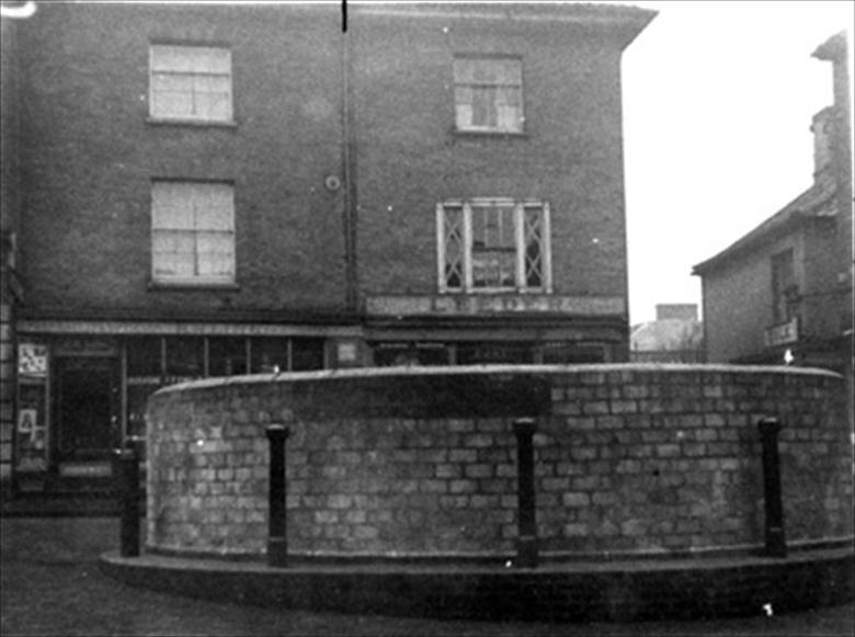 Photograph. WW2 reservoir, erected in North Walsham Market Place in case of incendary attack. (North Walsham Archive).